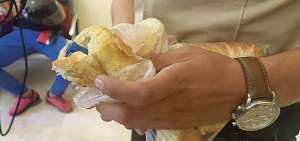 Un agente muestra el pan que ocultaba paquetes con las sustancias sujetas a fiscalizaci&oacute;n.