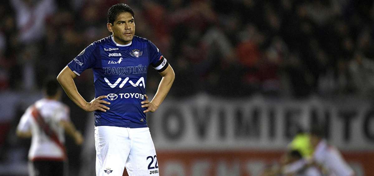 El defensa Edward Zenteno se lamenta por la derrota, mientras los jugadores de River celebran atr&aacute;s.   