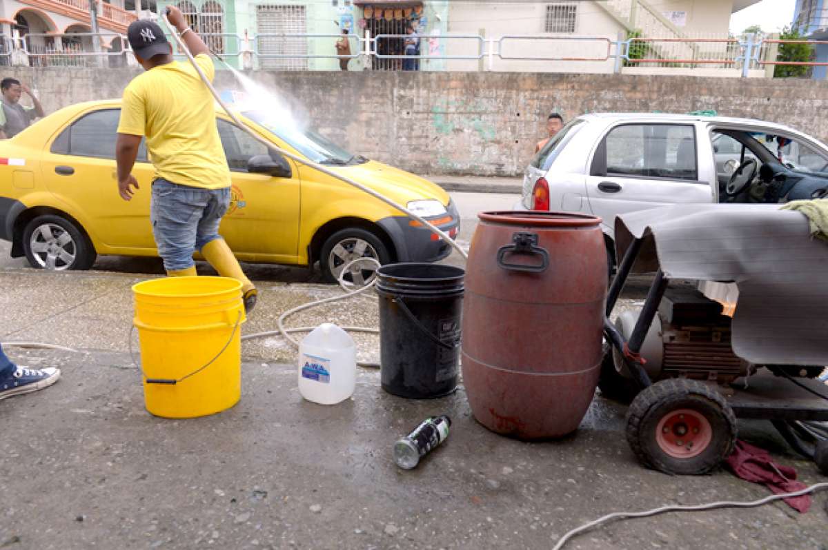 Los lavadores de carros que hallaron local se quejan por la disminuci&oacute;n de clientes debido a la competencia de los informales. Foto: Karly Torres / El Tel&eacute;grafo