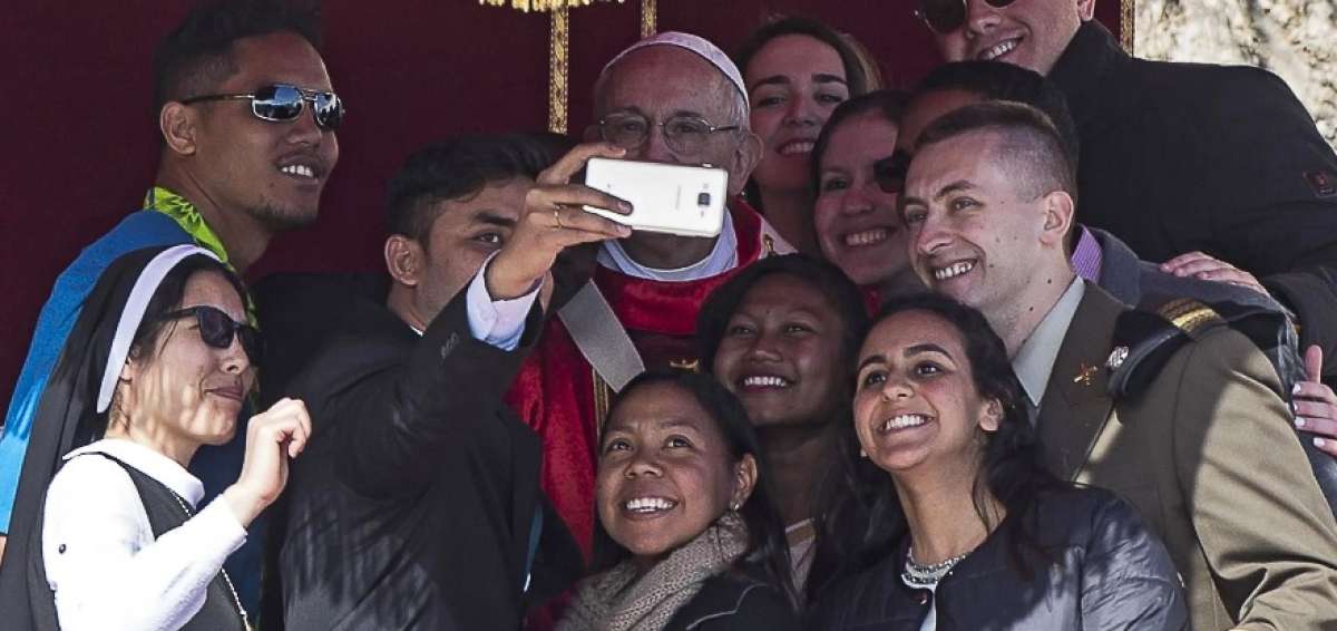 El papa Francisco (C) posa para un selfie con fieles durante la Misa del Domingo de Ramos en la Plaza de San Pedro, en la Ciudad del Vaticano.