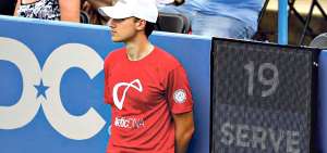 Un recogepelotas se para junto al reloj que limita el tiempo para realizar el saque, durante un partido entre Kei Nishikori y Alexander Zverev.