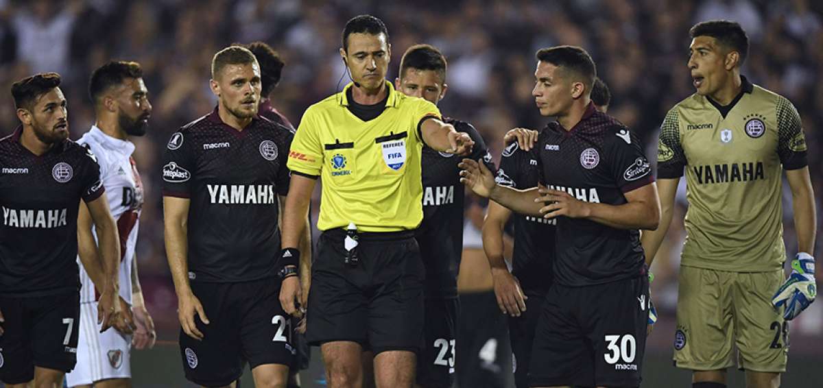 El &aacute;rbitro colombiano Wilmar Rold&aacute;n (der.) decreta tiro penal para Lan&uacute;s, luego de revisar la acci&oacute;n en la pantalla del videoarbitraje.     