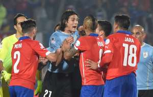 &Eacute;dinson Cavani (centro) intenta increpar al &aacute;rbitro del partido luego de recibir la segunda tarjeta amarilla; Arturo Vidal, de Chile, busca controlar al uruguayo. Foto: AFP