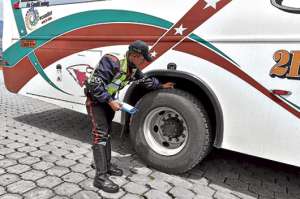 El agente del Municipio, Pablo Guanotu&ntilde;a, verifica que el labrado de las llantas del bus interprovincial sea el adecuado para autorizar su salida. Foto: Foto: Miguel Jim&eacute;nez.