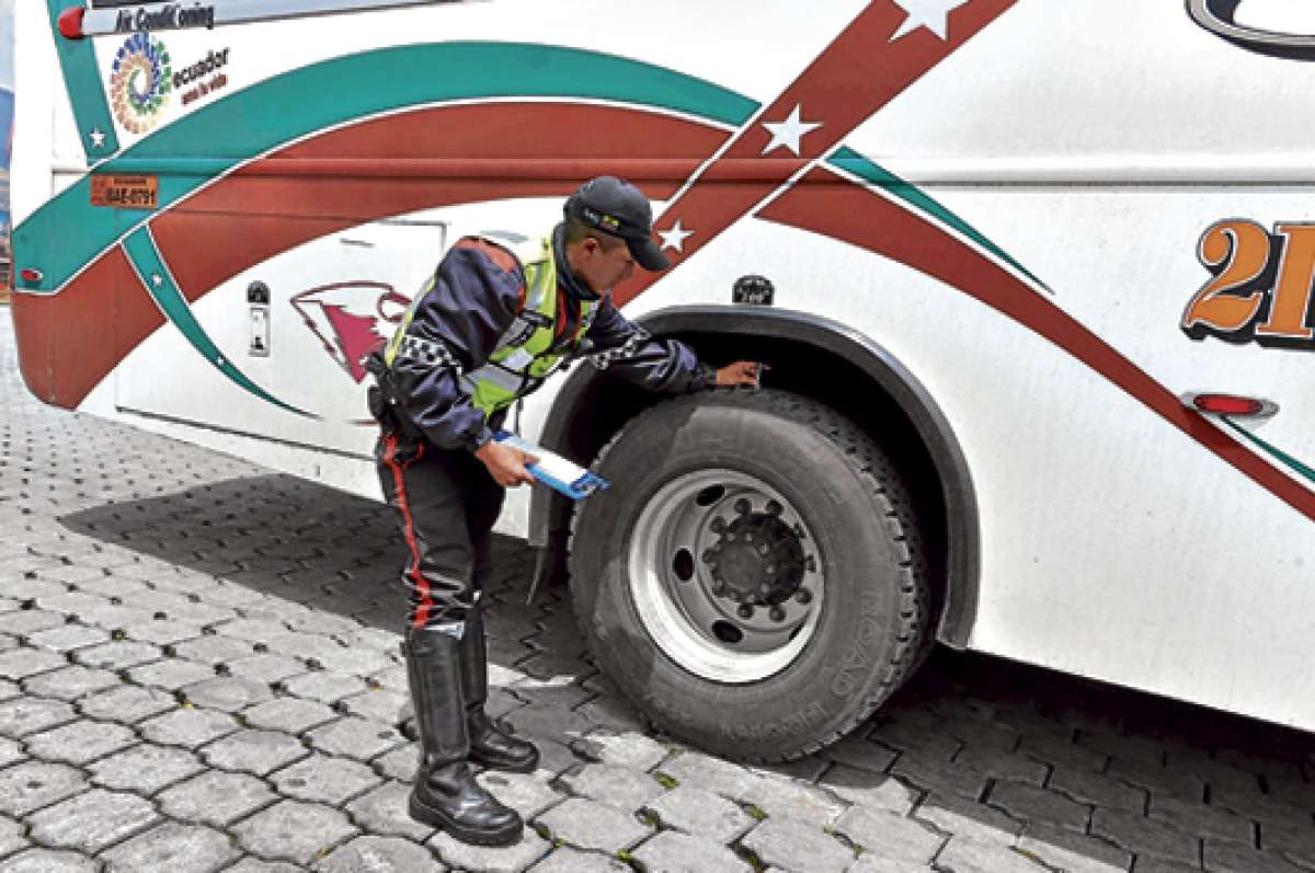 El agente del Municipio, Pablo Guanotu&ntilde;a, verifica que el labrado de las llantas del bus interprovincial sea el adecuado para autorizar su salida. Foto: Foto: Miguel Jim&eacute;nez.