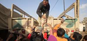 Un soldado reparte comida y agua a ni&ntilde;os iraqu&iacute;es desplazados por los combates entre el ej&eacute;rcito y yihadistas. 