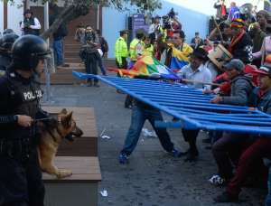 Momentos en que Salvador Quishpe (sombrero negro) junto a otros manifestantes agred&iacute;an a los polic&iacute;as con las vallas que se instalaron en el Centro Hist&oacute;rico de Quito. Foto: &Aacute;lvaro P&eacute;rez/El Tel&eacute;grafo