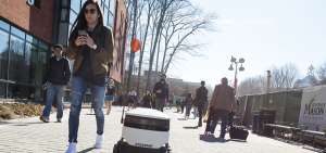En la fotograf&iacute;a se muestra un robot mientras entrega comida junto a unos transe&uacute;ntes en el campus de la Universidad George Mason, en Virginia (EE.UU.).