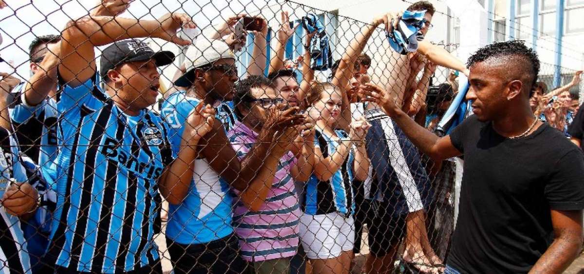 Miler Bola&ntilde;os (der.) a su llegada al aeropuerto de Porto Alegre, el pasado 8 de febrero, saluda a los hinchas.