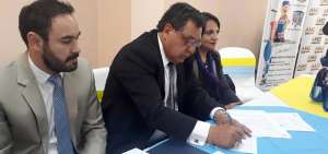 El alcalde de Latacunga, Patricio S&aacute;nchez (centro), firma el acuerdo acompa&ntilde;ado de Leonel Chica (izq.), ejecutivo de la AME.