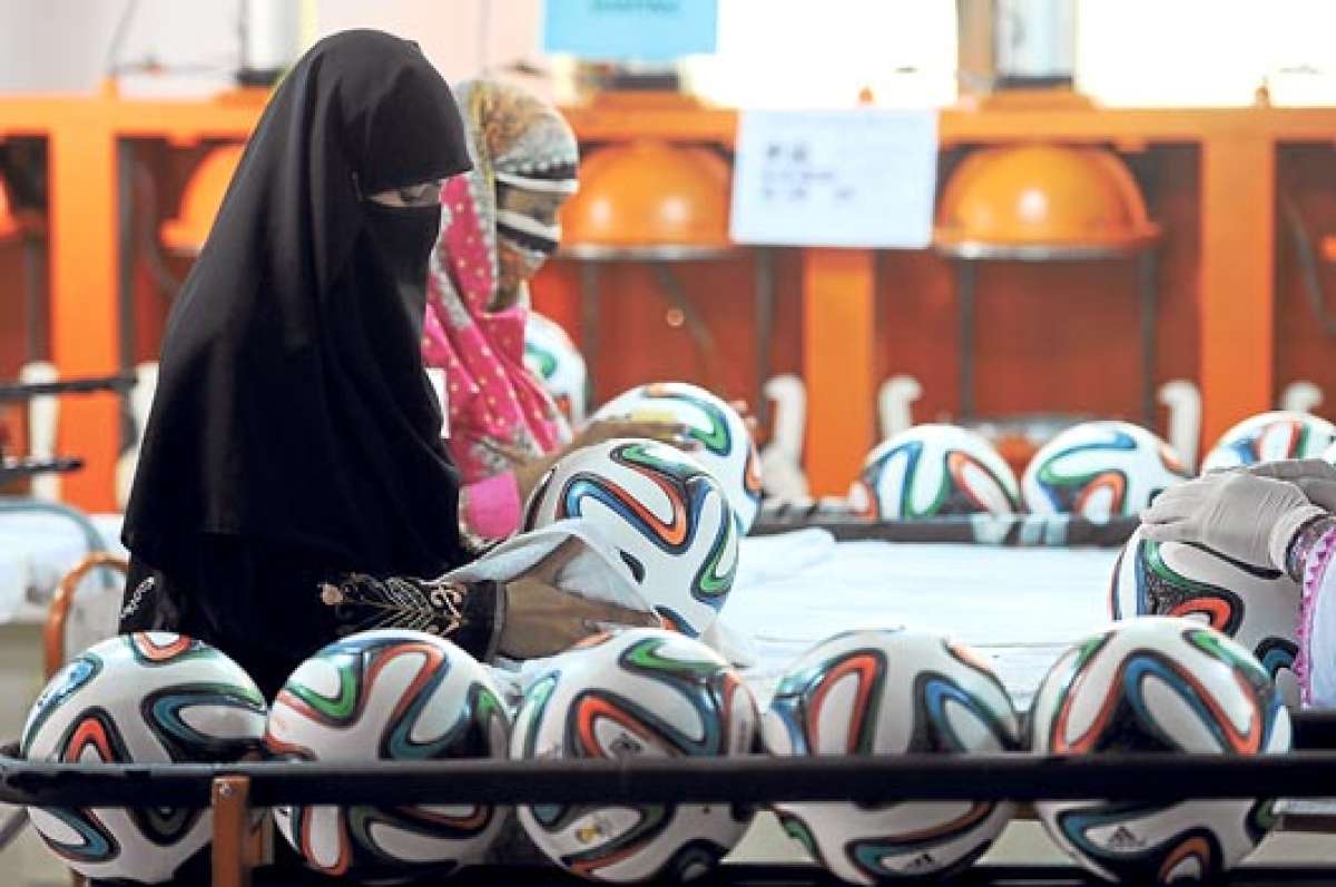 Trabajadoras musulmanas limpian los balones reci&eacute;n fabricados antes de someterlos a exigentes pruebas de resistencia. Foto: AFP.