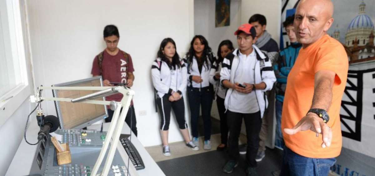 Geovanny M&eacute;ndez, director de programaci&oacute;n, indica a los estudiantes el funcionamiento de la radio.