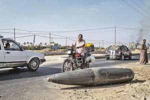 Ciudadanos gazat&iacute;es observan un misil sin explotar, lanzado por Israel durante los bombardeos. Foto: AFP