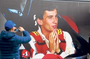Un apasionado al automovilismo fotograf&iacute;a un p&oacute;ster gigante de Senna durante la exposici&oacute;n que se hace todos los a&ntilde;os en Imola, Italia. Foto: EFE