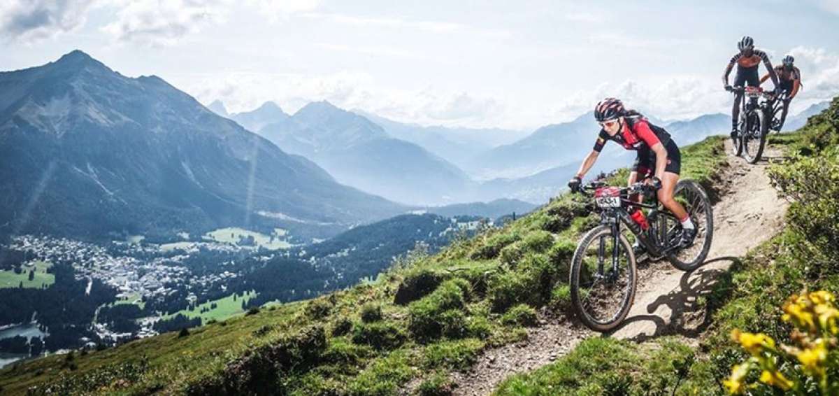 La ciclomonta&ntilde;ista Ana Isabel Idrovo (adelante) desciende en su bicicleta por un camino sinuoso. 
