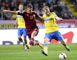 El ruso Oleg Shatov (i.) y el sueco Sebastian Larsson disputan el bal&oacute;n durante el encuentro. Foto: AFP