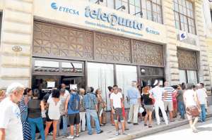Decenas de personas hacen fila para ingresar a un telepunto y contratar el servicio de correo para sus tel&eacute;fonos m&oacute;viles en La Habana (Cuba). La afluencia de usuarios ha tomado por sorpresa a la entidad estatal que oferta el servicio. Foto: EFE