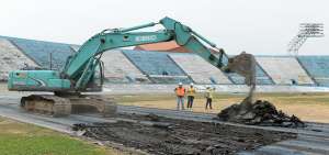 Luego de la colocaci&oacute;n de la primera piedra, iniciaron los trabajos de reconstrucci&oacute;n de la pista atl&eacute;tica del estadio Modelo. Una retroexcavadora retira el material sint&eacute;tico de la pista anterior.    