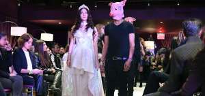 Un hombre vestido  de negro con el rostro cubierto con una m&aacute;scara de cerdo acompa&ntilde;&oacute; a las modelos en la pasarela.