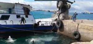 Momento de la maniobra de carga que deriva en el hundimiento de la gabarra, contenedor y gr&uacute;a.