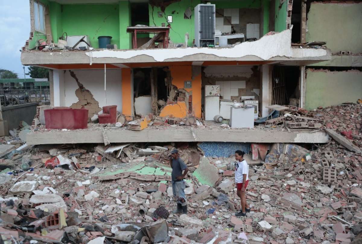 Residentes observan varios bloques de viviendas da&ntilde;ados por los terremotos en la localidad de Catia La Mar, en el estado costero de La Guaira (Venezuela) este jueves. 