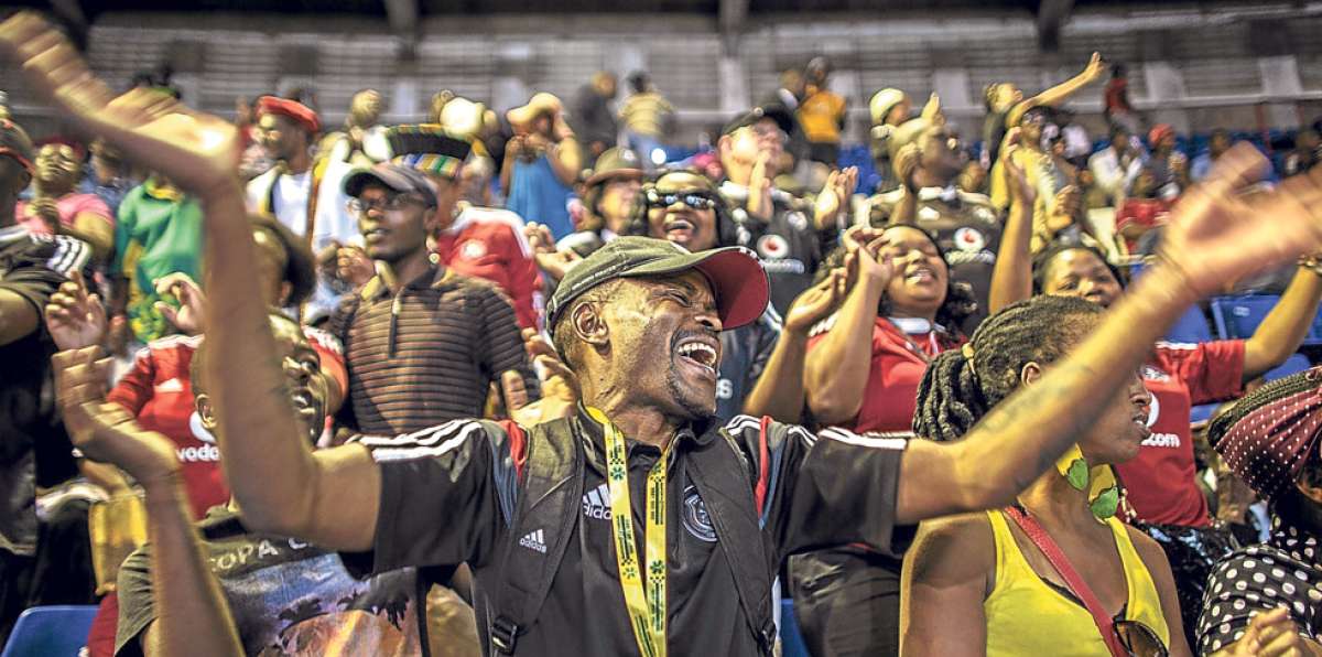 Un grupo de sudafricanos llora la muerte de los deportistas durante un acto en estadio Johannesburgo. Foto: AFP