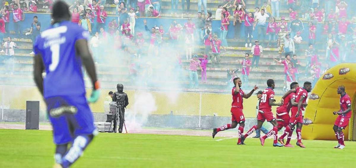 Los jugadores de El Nacional celebraban el empate 1-1 frente a LDU-Q, mientras desde las gradas su barra brava arrojaba bengalas a la pista del Atahualpa.
