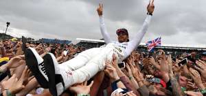 El piloto brit&aacute;nico Lewis Hamilton festeja con los miembros de su escuder&iacute;a (Mercedes) al final del Gran Premio de Silverstone, disputado este domingo.