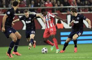 Joel Cambell (c), del Olympiakos, disputa la pelota con Michael Carrick (d) y con Tom Cleverley (i), ambos del Manchester United. R&iacute;o Ferdinand (de perfil) observa la jugada. Foto: EFE