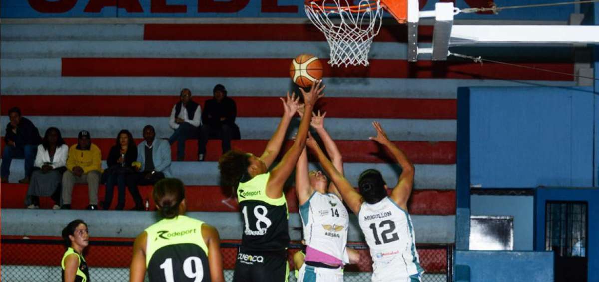 La p&iacute;vot cubana Zuleida Aties (18), del club Victoria, lanza ante la marcaci&oacute;n de Stefany Narv&aacute;ez (14) y Roc&iacute;o Rodr&iacute;guez (12) de Triple E de Cuenca. 