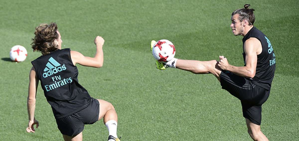 El delantero Gareth Bale (der.) intenta dominar el bal&oacute;n ante la marca de Luka Modric. 