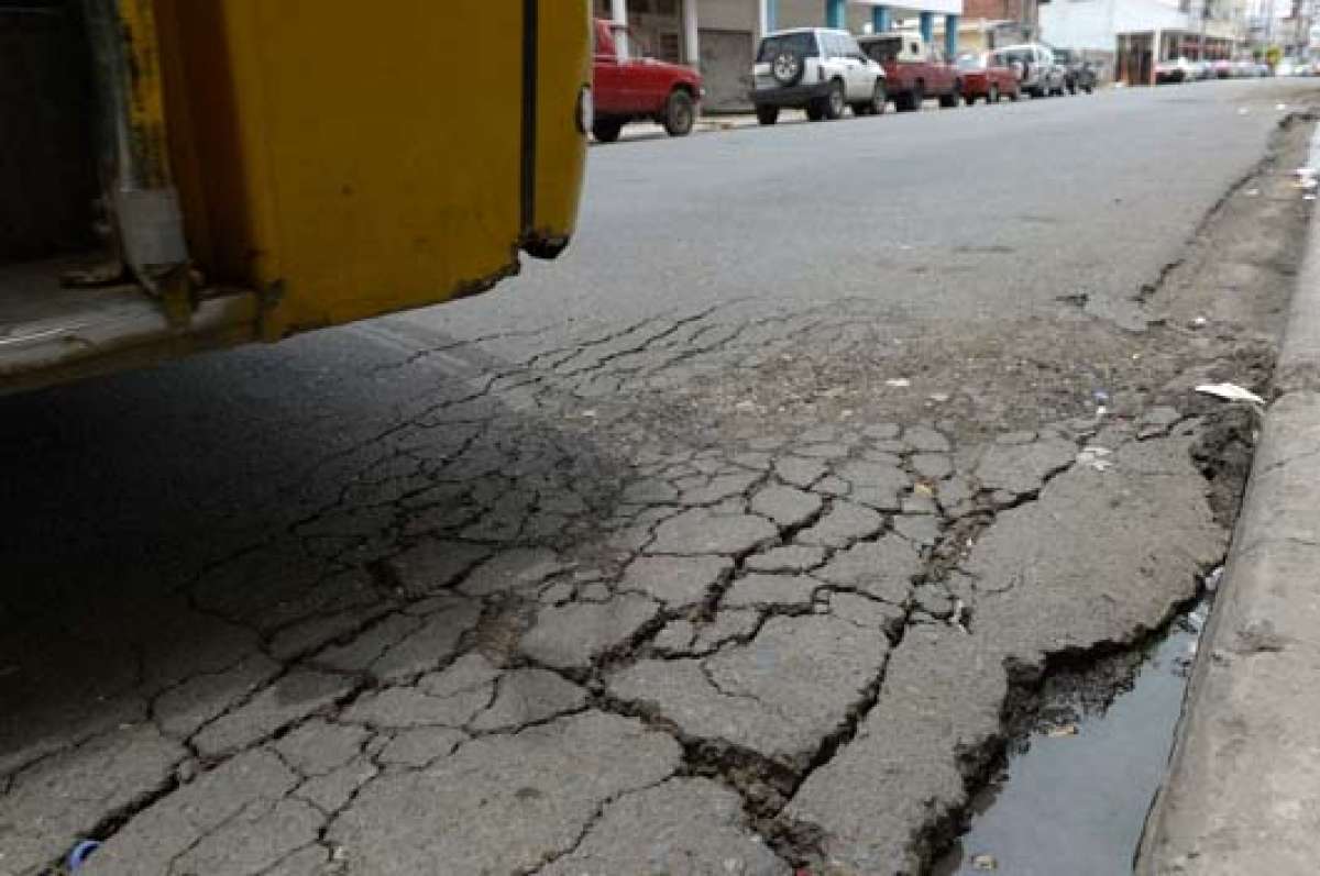 El transporte que viene de Dur&aacute;n debe esquivar un bache en la calle Quisqu&iacute;s. Foto: Lylibeth Coloma