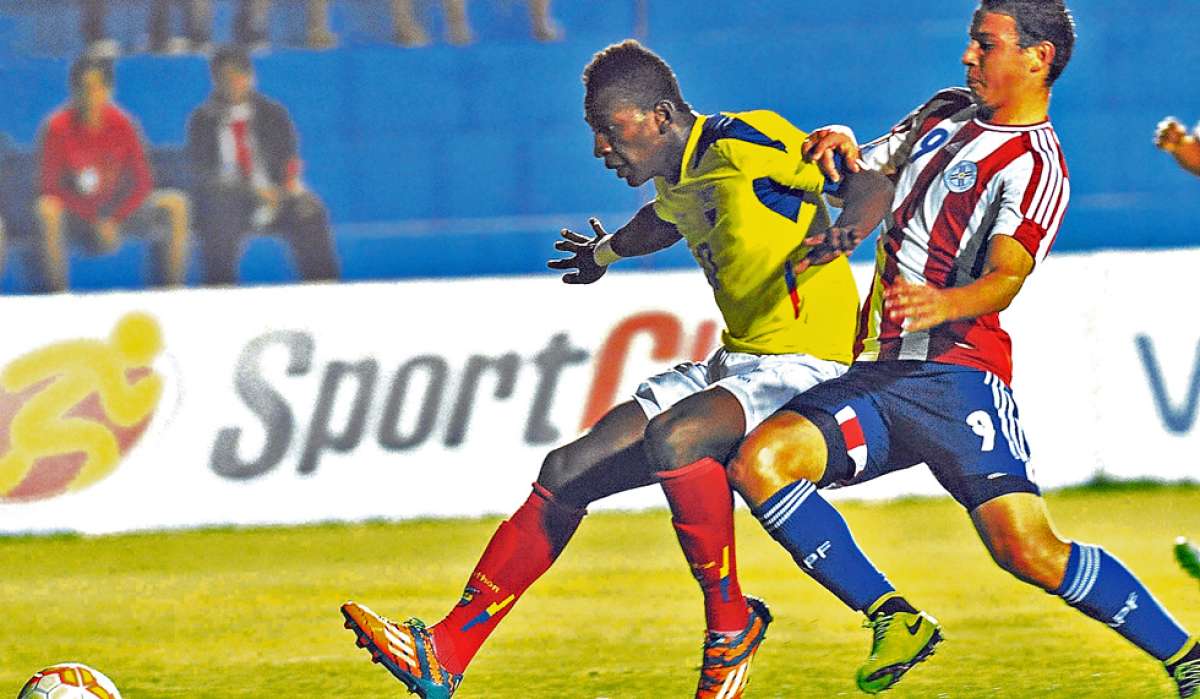 El defensa ecuatoriano Pervis Estupi&ntilde;&aacute;n (izq.) disputa el bal&oacute;n con el paraguayo Sebasti&aacute;n Ferreira, durante el partido jugado en Capiat&aacute;. Foto: AFP