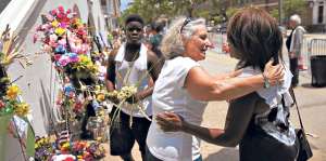 Ciudadanos se abrazan fuera de la iglesia de Charleston, Carolina de Sur, para recordar un mes de la matanza. Foto: AFP