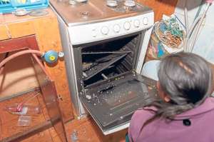 Susana Gallegos, hermana de una de las v&iacute;ctimas, revisa la cocina donde ocurri&oacute; la explosi&oacute;n. Foto: Miguel Jim&eacute;nez / El Tel&eacute;grafo