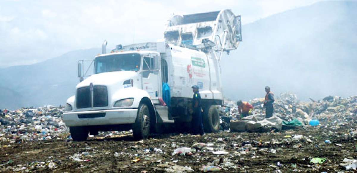 Camiones que recolectan la basura de Riobamba depositan las cargas diarias  en el botadero a cielo abierto, cerca de ellos esperan los minadores que buscan botellas, cart&oacute;n, papel, etc. Foto: ELIZABET MAGGI para El Tel&eacute;grafo