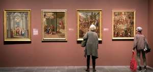 Dos personas observan algunos cuadros que forman parte de la muestra &ldquo;Pintado en M&eacute;xico&rdquo;, que recoge obras de la &eacute;poca colonial de ese pa&iacute;s.