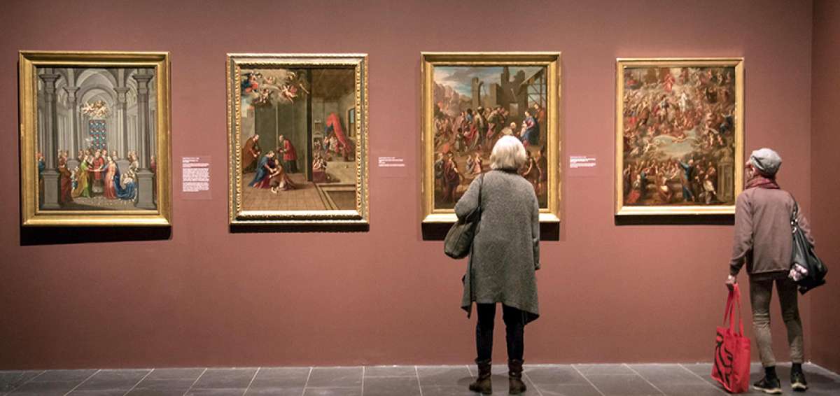 Dos personas observan algunos cuadros que forman parte de la muestra &ldquo;Pintado en M&eacute;xico&rdquo;, que recoge obras de la &eacute;poca colonial de ese pa&iacute;s.
