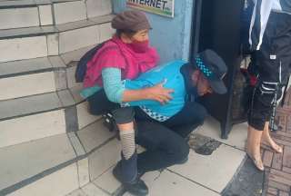 Agente de control de Quito cargó a una mujer en su espalda