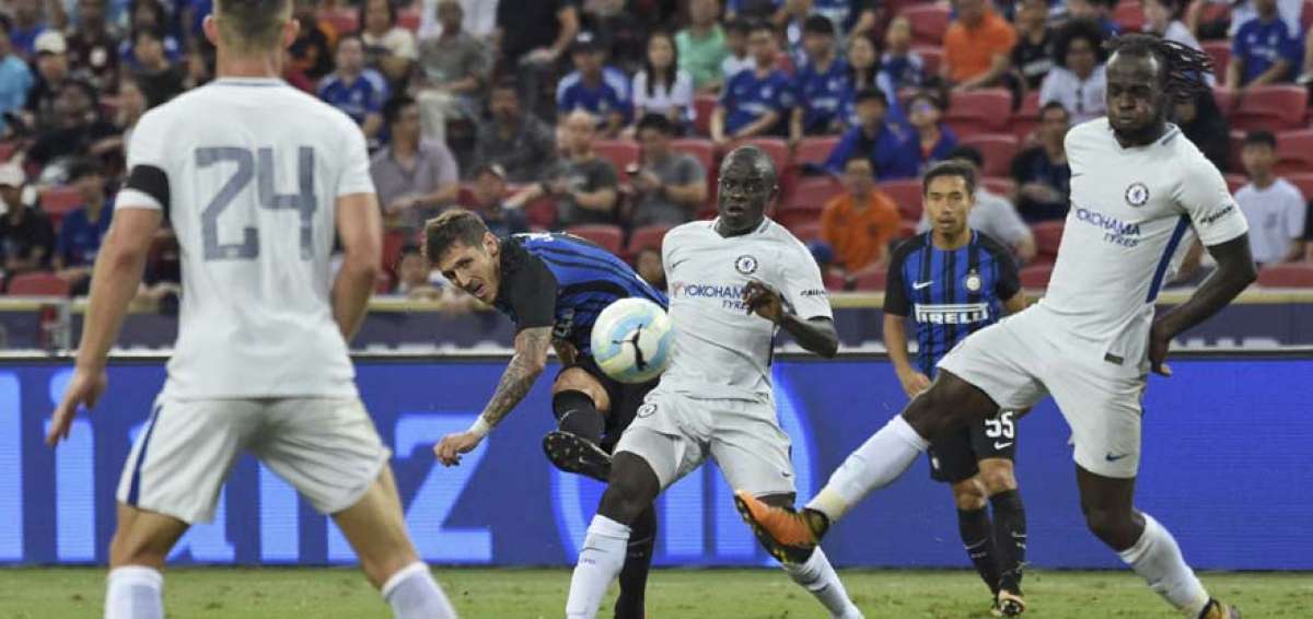 El delantero montenegrino Stevan Jovetic (centro) ejecuta un disparo que intentan bloquear los defensas del Chelsea durante el partido de ayer.   