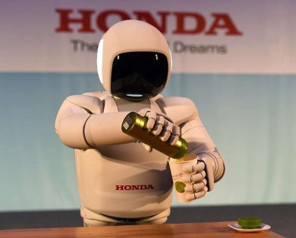 ASIMO, el robot humanoide de Honda, sirve l&iacute;quido en un vaso durante la presentaci&oacute;n de la &uacute;ltima versi&oacute;n en Nueva York. Foto: AFP