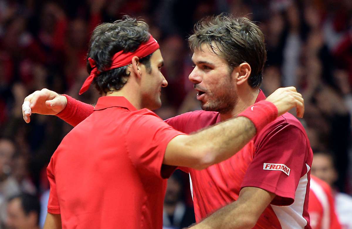Roger Federer (i.) y Stanislas Wawrinka celebran el segundo punto logrado por los suizos. Foto: AFP