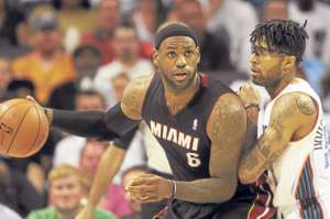 LeBron James (izq.) protege la pelota ante la marca de un jugador de los Bobcats. Foto: EFE