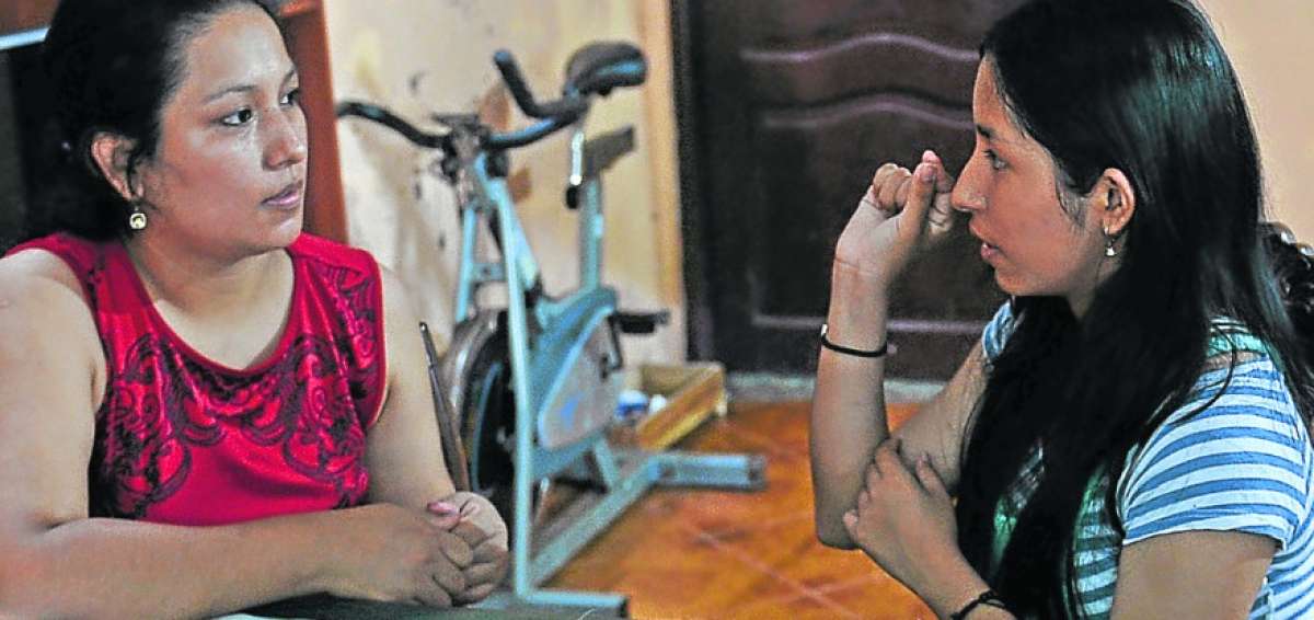 Diana Goyes (izquierda) y su hija Angie Indacochea (derecha) conversan, a trav&eacute;s del lenguaje de se&ntilde;as, sobre la prueba Ser Bachiller.