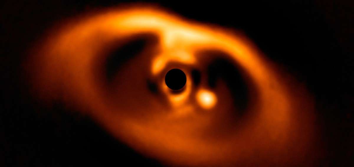 El joven planeta llamado PDS 70b es el punto brillante a la derecha de un centro oscuro, ubicado a 3.000 millones de kil&oacute;metros de la estrella central.