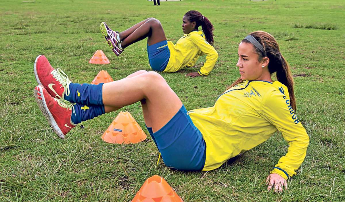 La volante Alexandra Salvador (abajo), quien estudia en Estados Unidos, y la defensa Tamara Angulo, del club Uni&oacute;n Espa&ntilde;ola, realizan abdominales durante una pr&aacute;ctica. Foto: Marco Salgado.