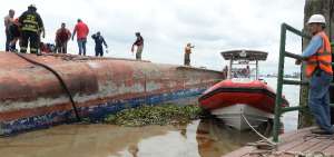 Varias personas ayudan al rescate luego de que se virara el barco.