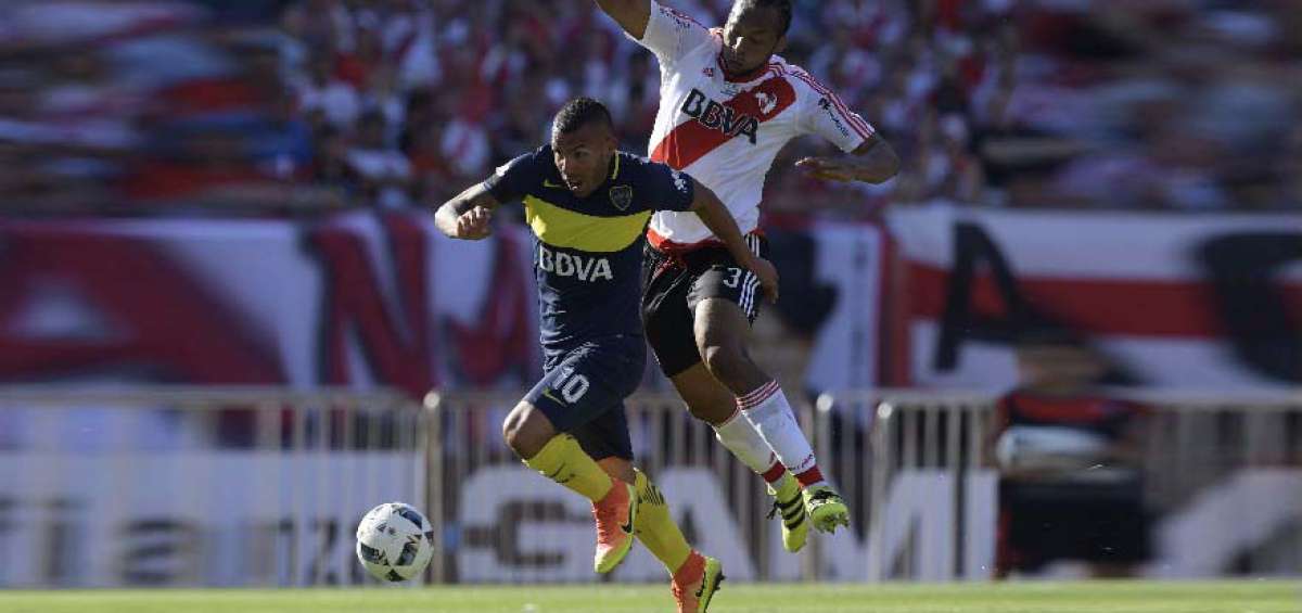 Arturo Mina (atr&aacute;s) intenta frenar al delantero de Boca Junior, Carlos T&eacute;vez, en el partido disputado el domingo pasado. 