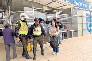 Dos agentes de polic&iacute;a escoltan a una mujer que solicit&oacute; custodia, mientras sale de una entidad financiera y se acerca a su veh&iacute;culo. Foto: Roberto Ch&aacute;vez | El Tel&eacute;grafo
