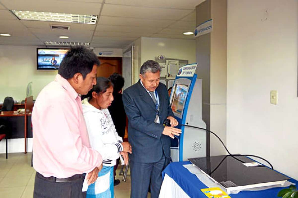 Un funcionario de la Empresa El&eacute;ctrica Ambato explica a los usuarios el mecanismo de cocci&oacute;n a inducci&oacute;n. Foto: Roberto Ch&aacute;vez / El Tel&eacute;grafo